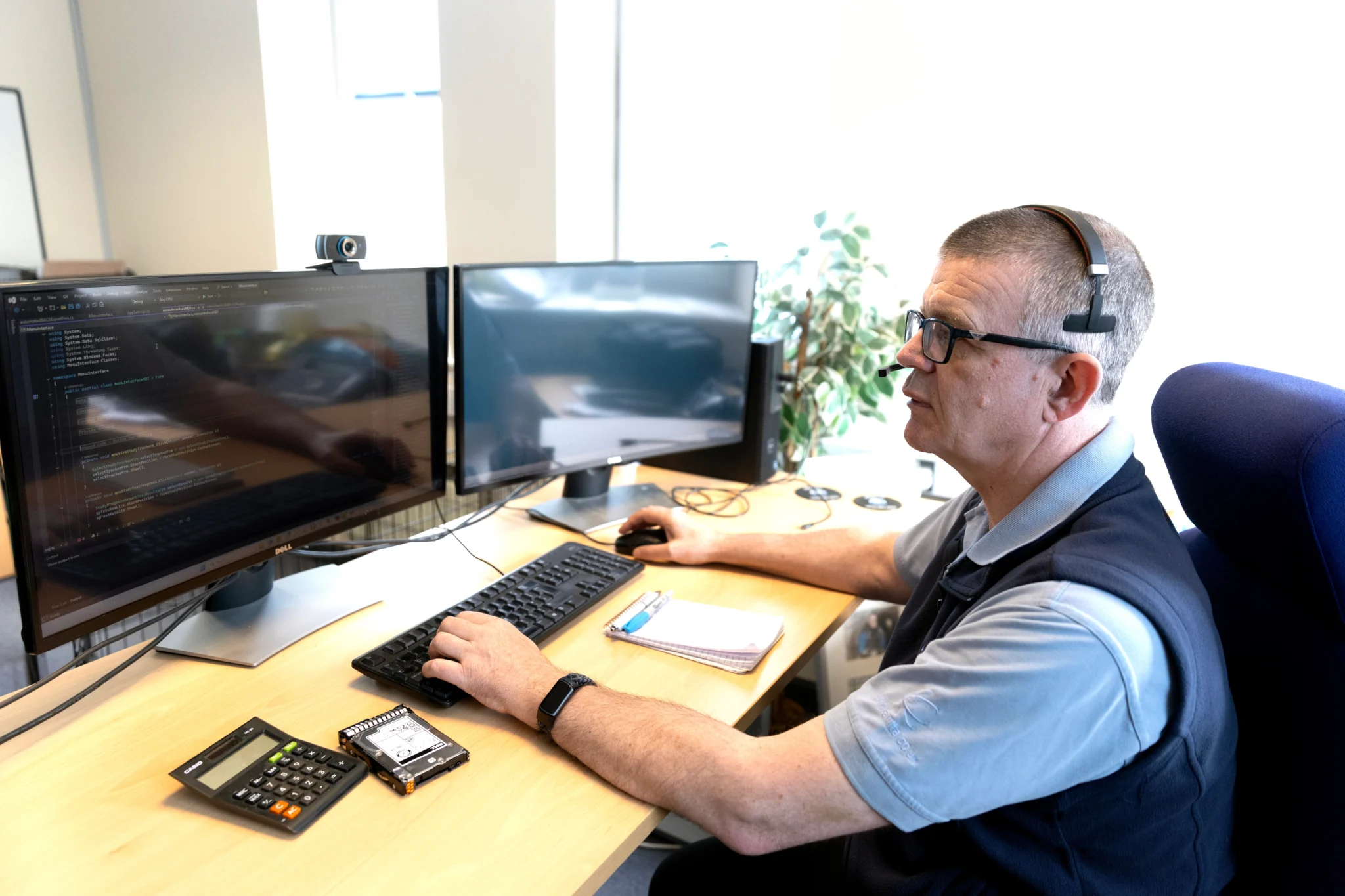 a man working infront of two monitors